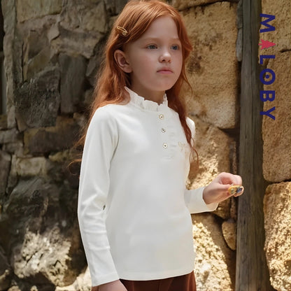 Chemise à col volanté blanche pour fille, idéale pour les occasions spéciales et les anniversaires.