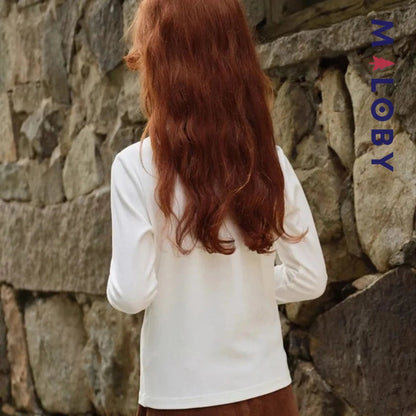 Chemise à col volanté blanche pour fille, idéale pour les occasions spéciales et les anniversaires.